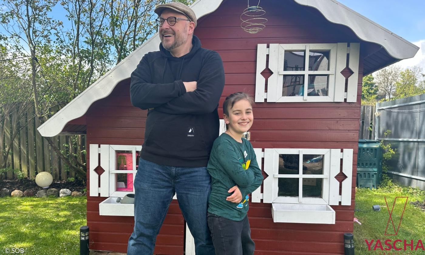 Ein Mann und ein Junge vor einem Gartenhaus