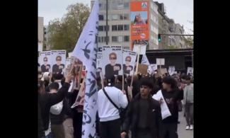 Menschen bei einer Demo mit Fahnen und Schildern