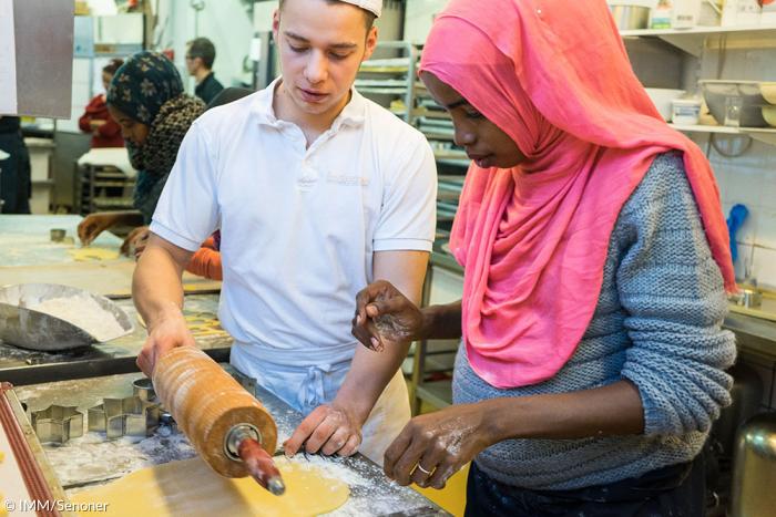 Somalierin und Bäcker in einer Münchner Backstube.