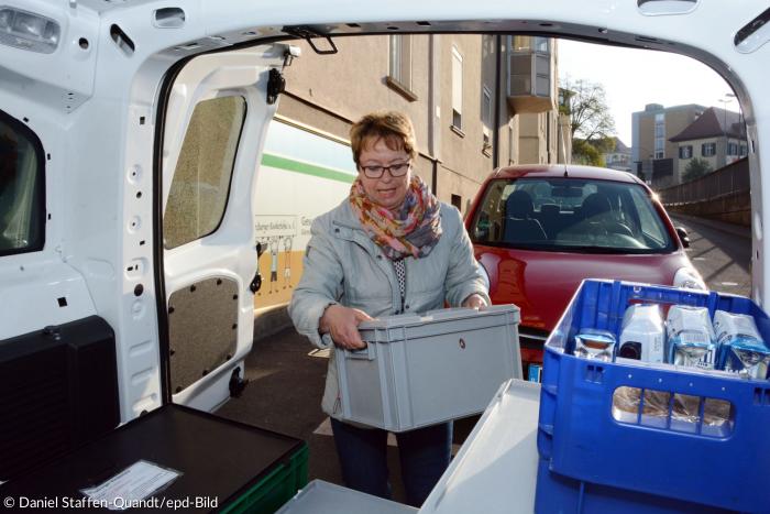 Die ehrenamtliche Mitarbeiterin Claudia Gawlik belädt den kleinen Kastenwagen der Kindertafel mit den Kisten für ihre Tour.