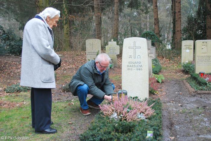 Franz Schiel entzündet für Doris Harslem eine Kerze auf dem Grab ihres Mannes.