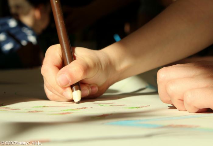 Kind malt Zeichnung Hand Buntstift