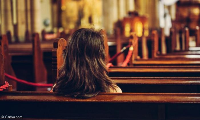 Eine Frau sitzt in der Kirche (Symbolbild)