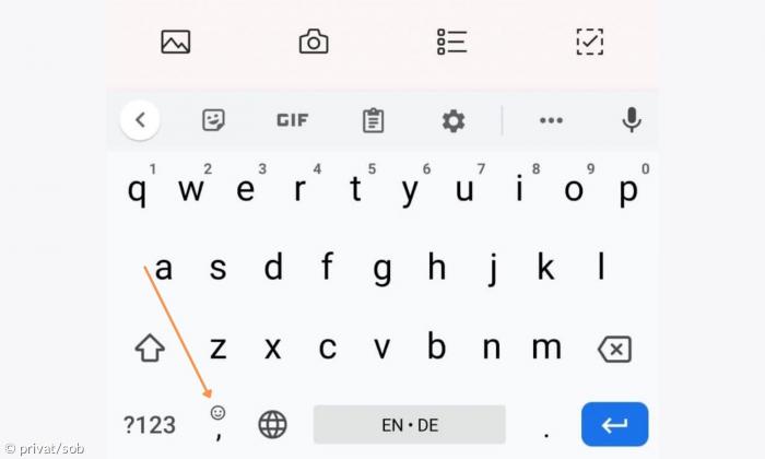 Eine OneNote-Tastatur mit einem Pfeil, der markiert, wo die Emojiauswahl zu finden ist