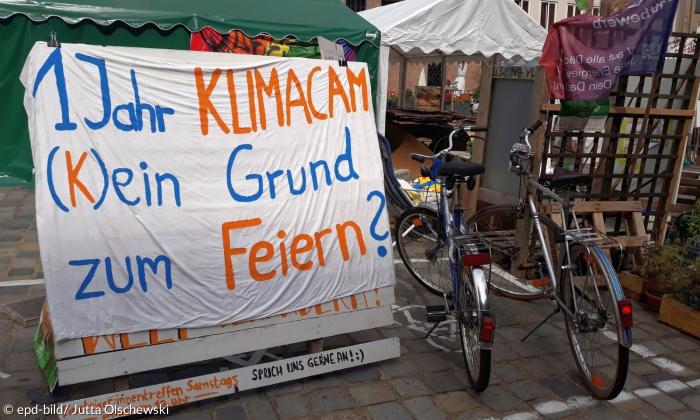 Ein Schild vor dem Klimacamp in Nürnberg mit der Aufschrift "1 Jahr Klimacamp. (K)ein Grund zum Feiern?"