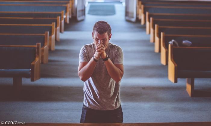 Ein Mann betet in einer Kirche