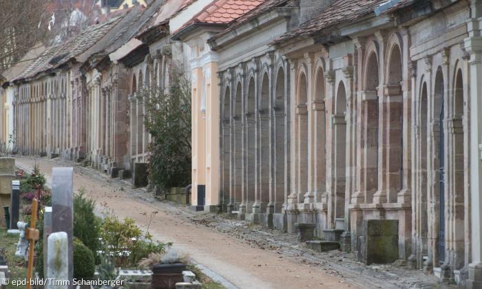 Viele steinerne Grüfte an einem kleinen Weg am Ansbacher Stadtfriedhof.