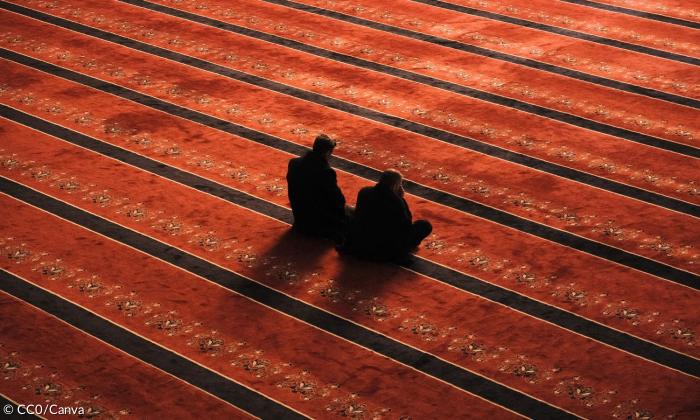 Zwei Menschen beten in einer Moschee