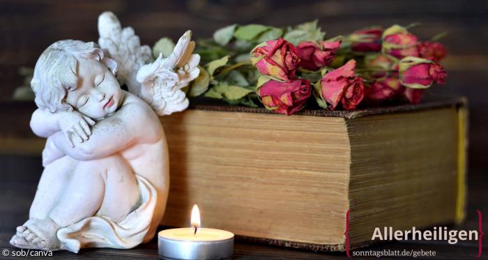 Ein Engel, eine Kerze, Rosen und die Bibel liegen auf dem Tisch 