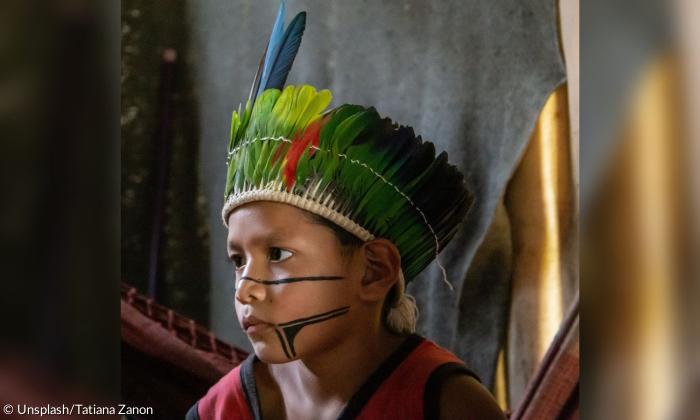 Ein indigener Junge mit Kopfschmuck