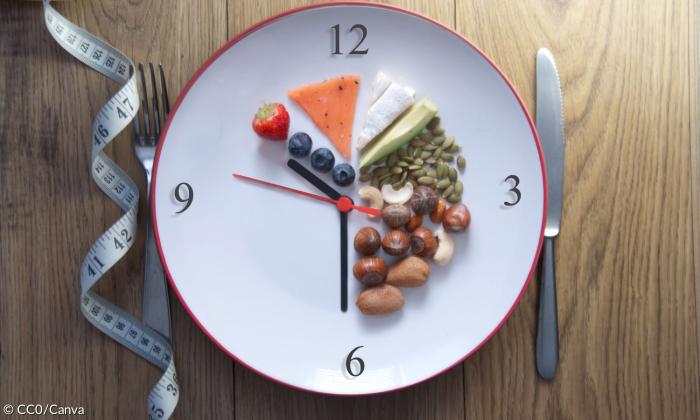 Ein Teller, der eine Uhr ist, mit Lebensmitteln