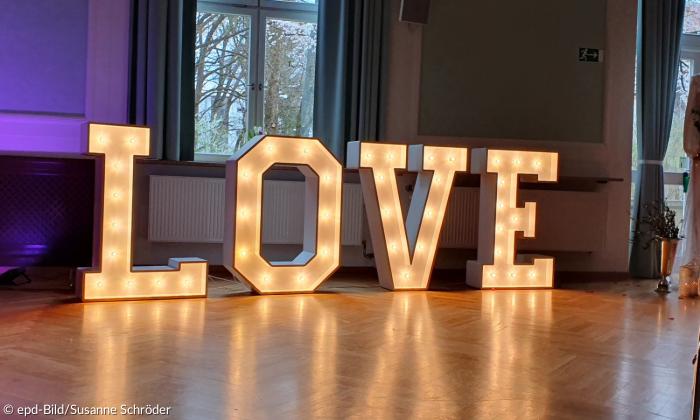 3D-dimensionale große Leuchtbuchstaben bilden in der Kirche das Wort Love.