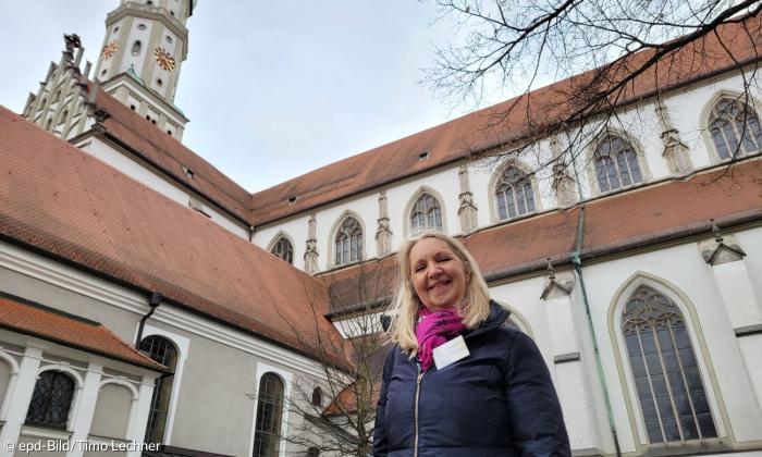 Gästeführerin Renate Braun zwischen den beiden Augsburger Kirchen, die dem Heiligen Ulrich gewidmet sind: der katholischen Basilika St.Ulrich und Afra und der evangelischen St. Ulrichkirche.