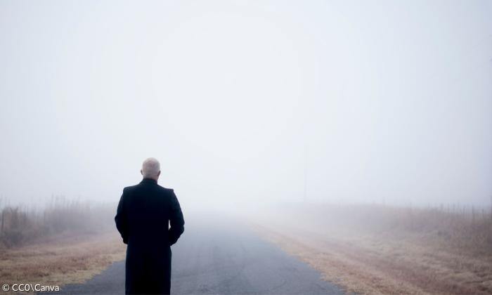 Ein Mann blickt in grauen Nebel