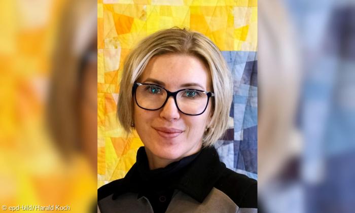 Eine Frau mit Brille, sie lächelt