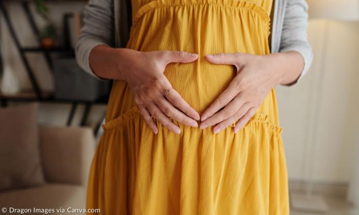 Ein Babybauch, darauf zwei Hände