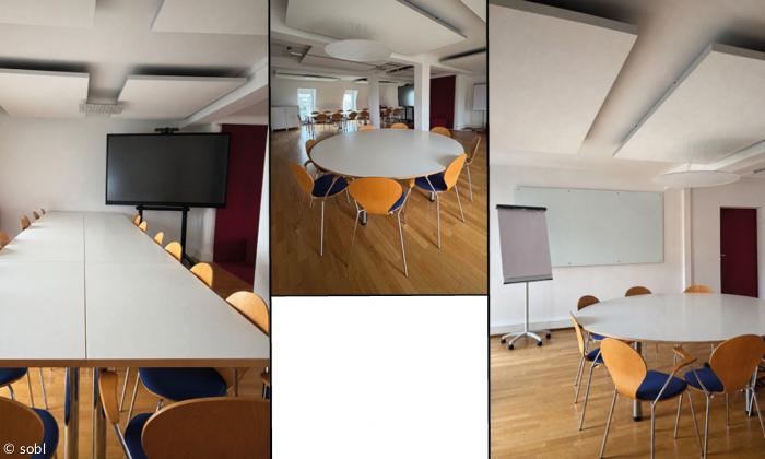 Moderner Konferenzraum mit Präsentationsbildschirm, Whiteboard, Flipchart, flexibler Bestuhlung, hellem Holzboden und großzügigem Platzangebot für Meetings, Workshops und Schulungen.