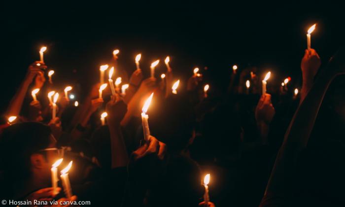 Menschen halten Kerzen in der Hand