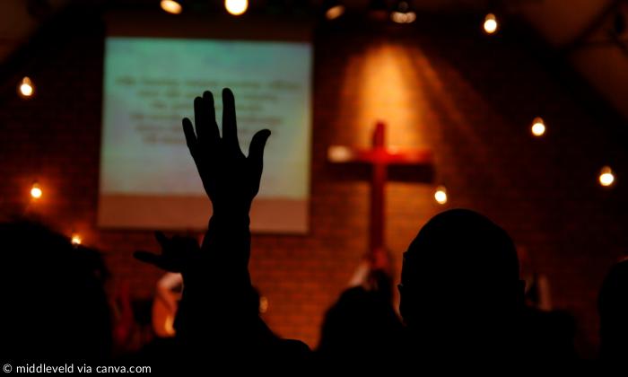 Mensch hebt Hand in einer Pfingstkirche