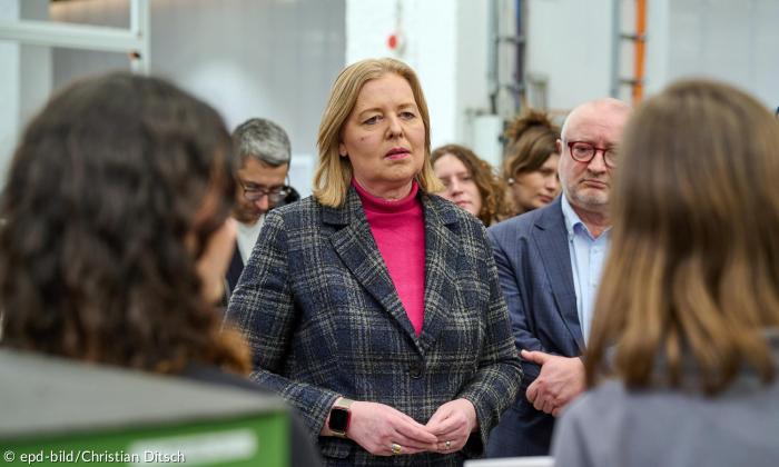Eine Frau steht unter mehreren Menschen