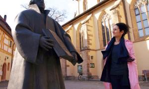 Die Weißenburger Dekanin Ingrid Gottwald-Weber und die Statue Martin Luthers vor der Kirche St. Andreas. Erst seit vier Jahren herrscht endlich Ruhe im Streit um den Standort des Kunstwerks.