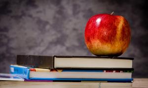 Schulanfang: Schulbücher auf einem Tisch mit Apfel