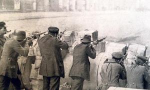 Stahlhelm, Mütze, Hut – Revolutionäre hinter Barrikaden aus Zeitungsstapeln: Im Berliner Zeitungsviertel wurde während des Spartakusaufstands im Januar 1919 besonders heftig gekämpft.