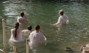 Erwachsene lassen sich im Jordan in Israel taufen