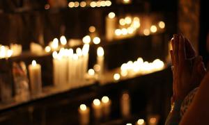 Beten in der Kirche mit Kerzenlicht