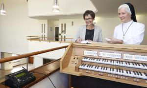 Die katholische Schwester Ehrengard und die evangelische Krankenhausseelsorgerin Verena Winkler mit dem Orgel-Automaten von Klaus Holzapfel im katholischen Waldkrankenhaus in Erlangen.                           