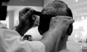 Ein Mann schneidet die Haare eines Kunden