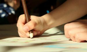 Kind malt Zeichnung Hand Buntstift