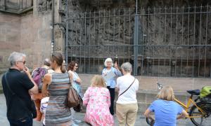 Stadtführerin Ulrike Hess zeigt Touristen das Schreyer-Landauer-Epitaph an St. Sebald in Nürnberg.