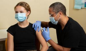Ein Arzt impft eine junge Frau
