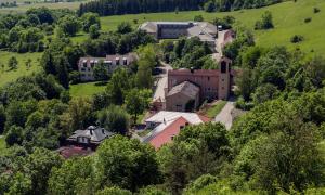 Das Bildungszentrum auf dem Hesselberg aus der Luft. Alle Gebäude sind zu sehen, umgeben von grünen Bäumen und Wiesen.