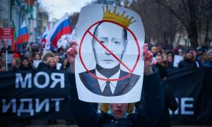 Ein Demonstrant hält ein Bild von Putin, auf dem dieser durchgestrichen ist