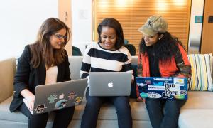 Drei weibliche Jugendliche mit Computern
