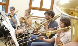 Menschen mit Blasinstrumenten sitzen in einem Raum