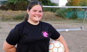 Eine junge Frau mit einem Fußball unter dem Arm