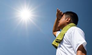 Ein Mann mit Handtuch um die Schultern schaut in die gleißende Sonne