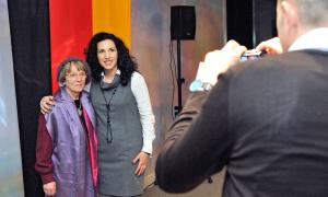 Zwei Frauen vor einer Deutschland-Fahne, ein Mann fotografiert beide