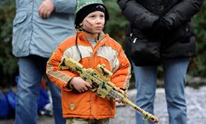 Ein kleiner Junge mit einer Plastik-Maschinenpistole