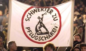 Demonstrant*innen mit einem "Schwerter zu Pflugscharen"-Plakat