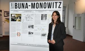 Eine Frau steht vor einem Ausstellungsplakat