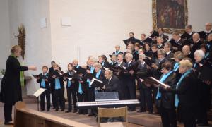 Mehrere Menschen stehen nebeneinander und singen