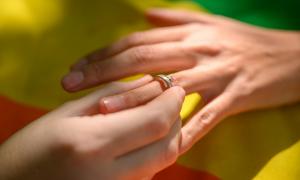 Eine Hand steckt einer anderen Hand einen Ring an den Finger