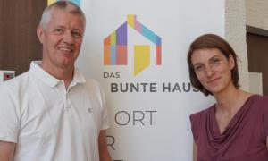 Ein Mann und eine Frau vor dem Schild "Das bunte Haus"