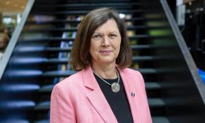 eine Frau im hellroten Blazer