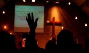 Mensch hebt Hand in einer Pfingstkirche