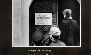 Schwarzweiß Bild von Menschen, die auf ein Plakat schauen
